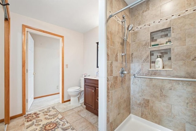 bathroom featuring tiled shower, tile patterned floors, vanity, and toilet