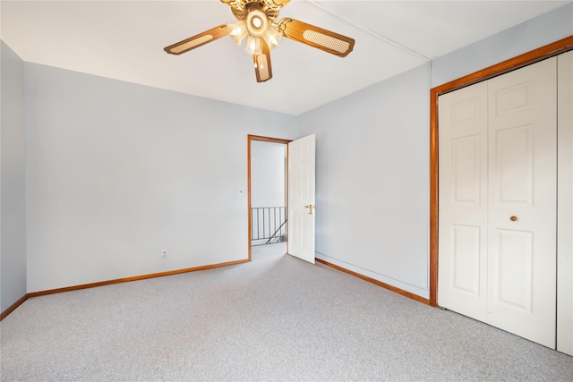 unfurnished bedroom with ceiling fan, light colored carpet, and a closet