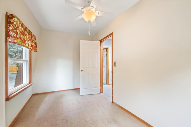 carpeted spare room featuring ceiling fan