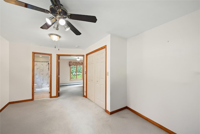 carpeted empty room featuring a baseboard radiator and ceiling fan