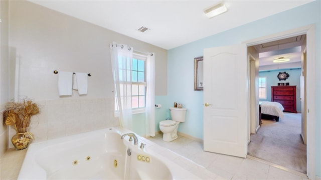 bathroom featuring a tub to relax in, tile patterned floors, and toilet