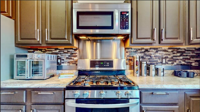 kitchen featuring backsplash, light stone counters, and stainless steel appliances