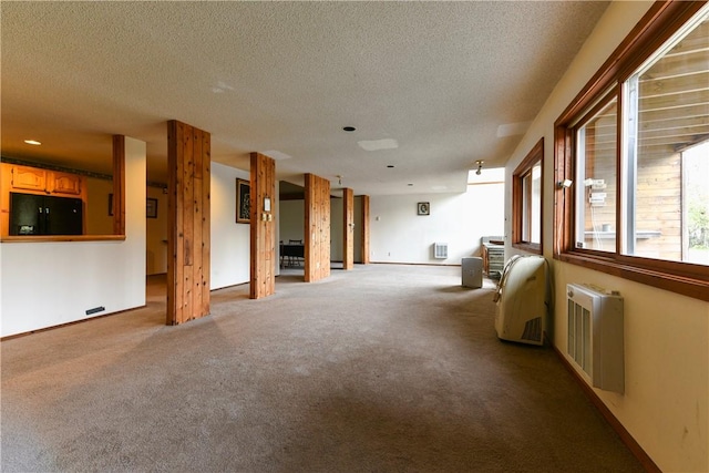 unfurnished living room featuring radiator, light carpet, and a textured ceiling