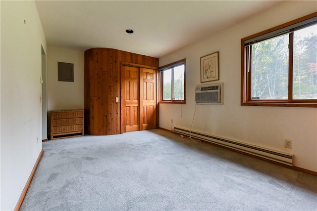 unfurnished bedroom featuring carpet flooring, multiple windows, a wall mounted AC, and a baseboard radiator