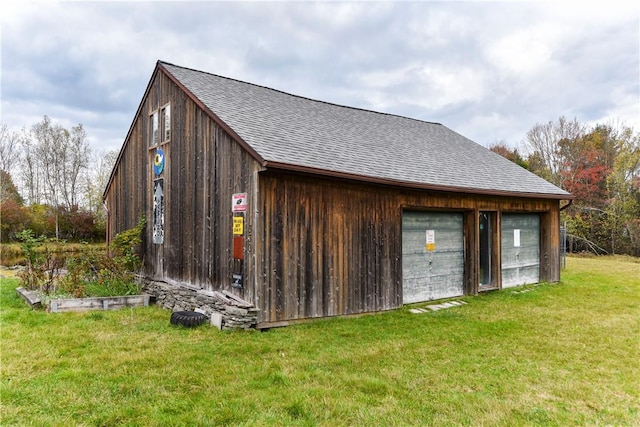 view of outbuilding featuring a garage and a yard