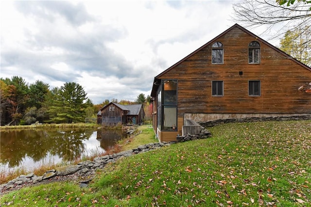 view of side of property with a yard and a water view