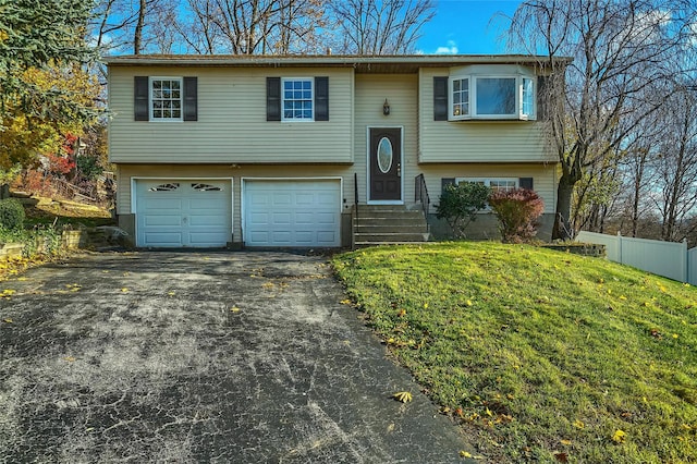 raised ranch with a garage and a front lawn