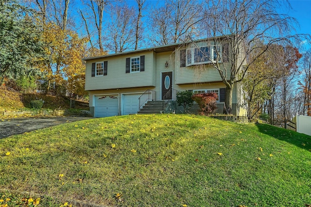 raised ranch featuring a garage and a front lawn