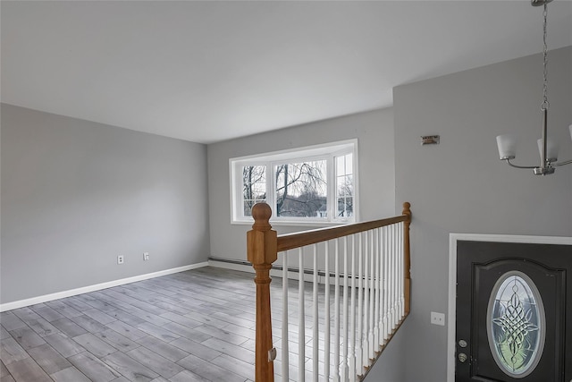 entryway with a chandelier, a baseboard radiator, and hardwood / wood-style flooring