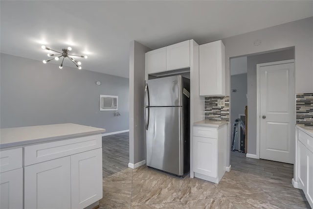 kitchen with stainless steel refrigerator, white cabinetry, and decorative backsplash