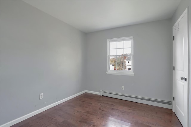 empty room featuring dark wood-type flooring and a baseboard radiator