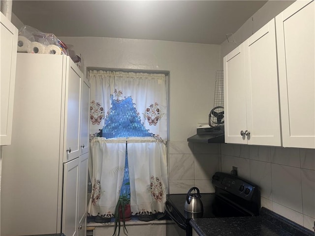 kitchen with ventilation hood, decorative backsplash, white cabinetry, and black electric range