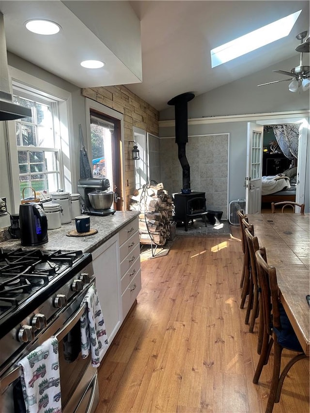 kitchen with tile counters, ceiling fan, wooden walls, and tasteful backsplash