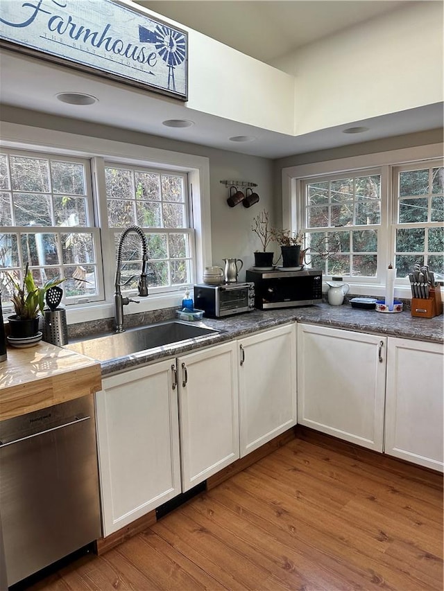 kitchen featuring white cabinets, wood-type flooring, and wooden walls