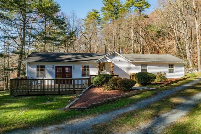 ranch-style house with a deck and a front lawn