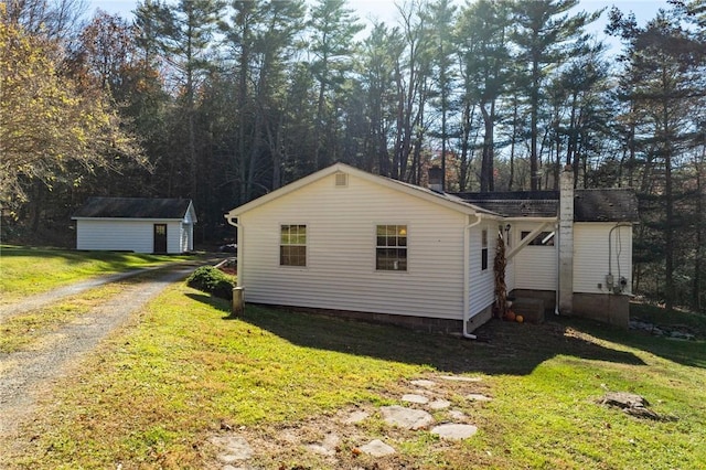 view of side of home featuring a yard and a shed