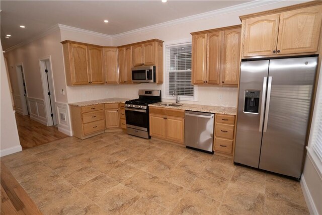 kitchen with light stone countertops, appliances with stainless steel finishes, crown molding, and sink