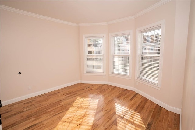 unfurnished room featuring hardwood / wood-style flooring, crown molding, and a wealth of natural light