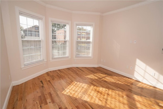 unfurnished room featuring wood-type flooring, crown molding, and a wealth of natural light