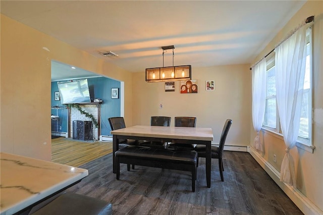 dining space with baseboard heating and dark hardwood / wood-style floors