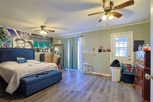 bedroom featuring hardwood / wood-style flooring, ceiling fan, and crown molding