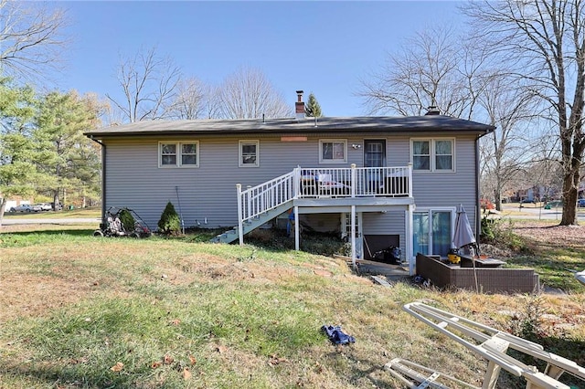 rear view of house featuring a lawn and a deck