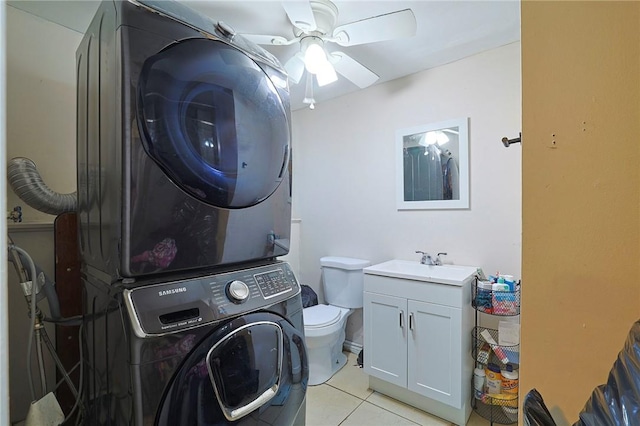 laundry room featuring ceiling fan, sink, light tile patterned flooring, and stacked washing maching and dryer