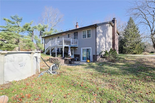 rear view of house featuring a deck and a lawn