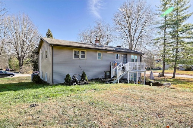 rear view of house with a lawn and a deck