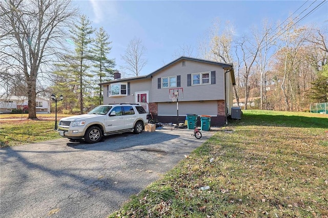 view of front of property featuring a front yard and central AC