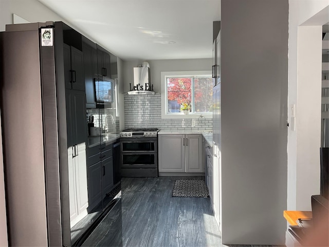 kitchen featuring decorative backsplash, dark hardwood / wood-style flooring, wall chimney exhaust hood, stainless steel appliances, and sink