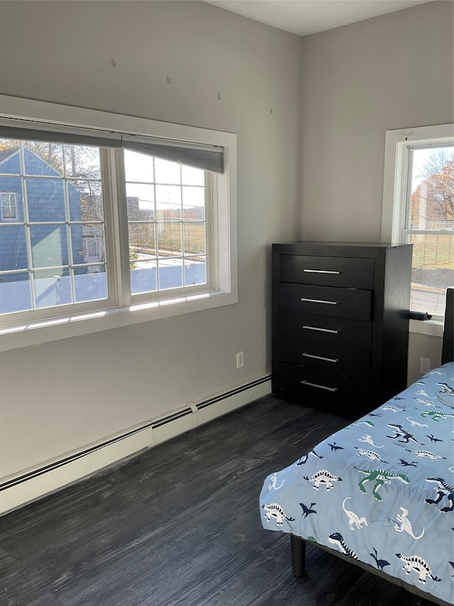 unfurnished bedroom featuring baseboard heating and dark wood-type flooring