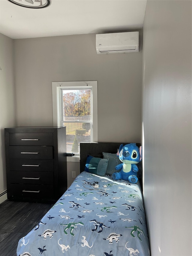 bedroom with dark hardwood / wood-style floors, a baseboard radiator, and a wall mounted AC