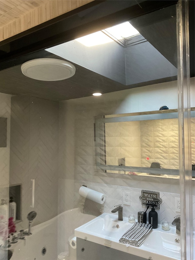 bathroom featuring shower / bathing tub combination, tasteful backsplash, and sink