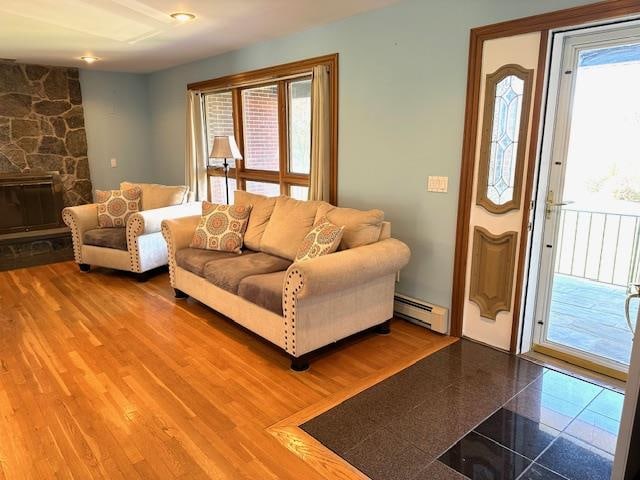 living room with a fireplace and a baseboard heating unit