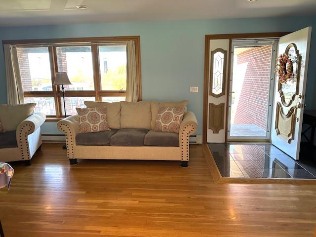 living room featuring hardwood / wood-style floors and a baseboard heating unit