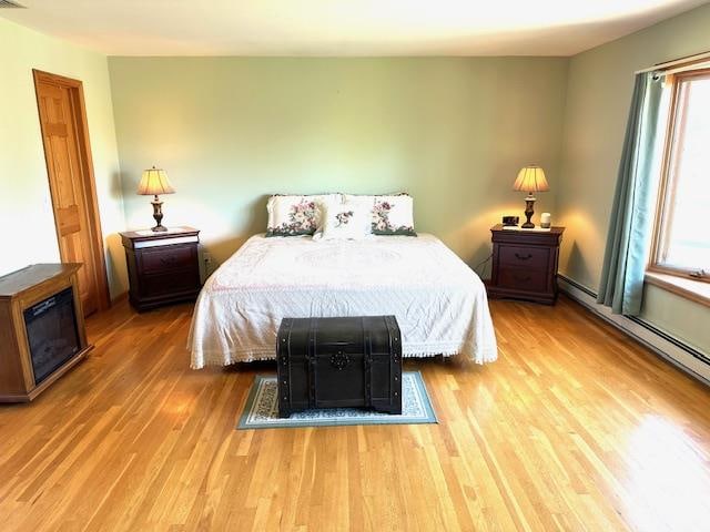 bedroom with wood-type flooring and multiple windows