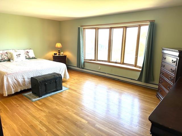 bedroom featuring light hardwood / wood-style floors and a baseboard radiator