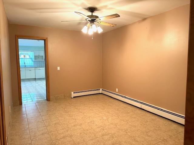 spare room with ceiling fan and a baseboard radiator