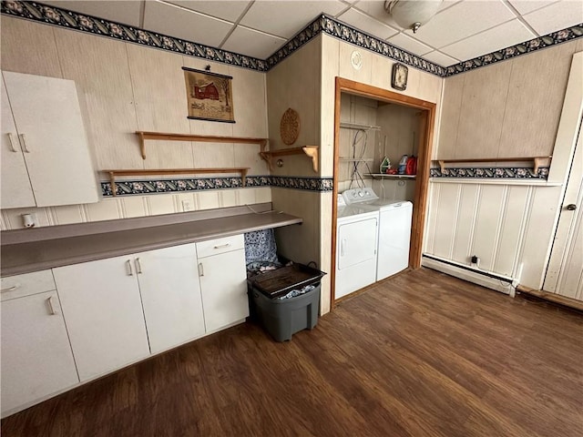 clothes washing area with washer and clothes dryer, dark hardwood / wood-style flooring, and baseboard heating