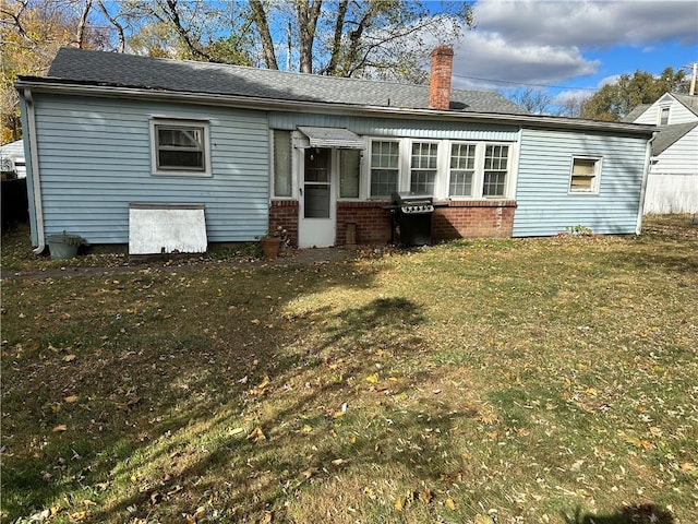 back of house featuring a lawn