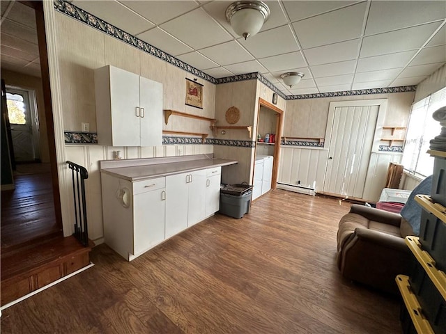 kitchen with dark hardwood / wood-style flooring, a drop ceiling, and baseboard heating