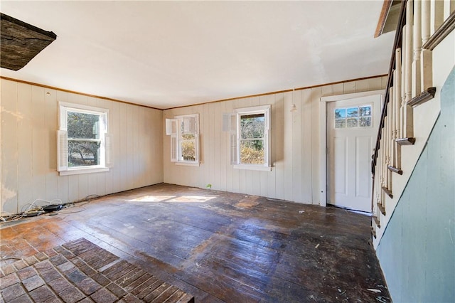 entryway featuring a healthy amount of sunlight and wood walls