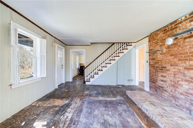 foyer with dark wood-type flooring and ornamental molding