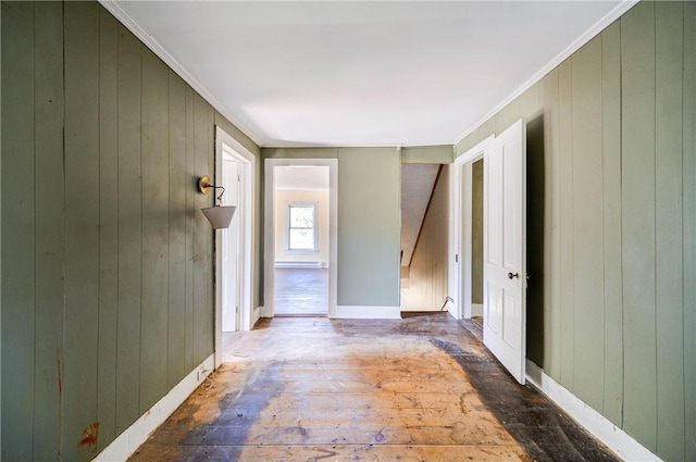 hall featuring wood-type flooring, crown molding, and wooden walls