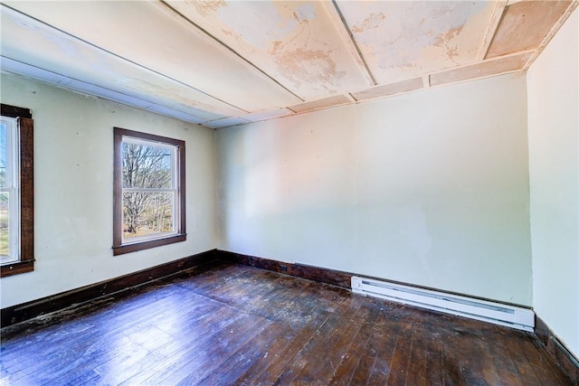 unfurnished room with dark hardwood / wood-style floors and a baseboard heating unit