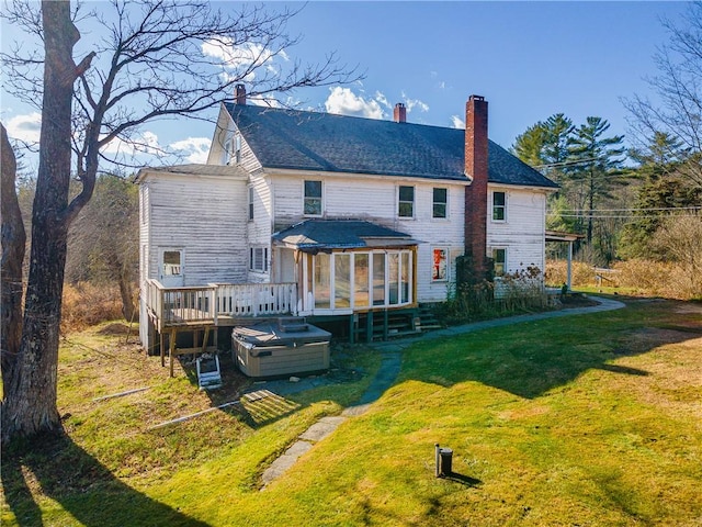 back of property with a lawn, a wooden deck, and a sunroom