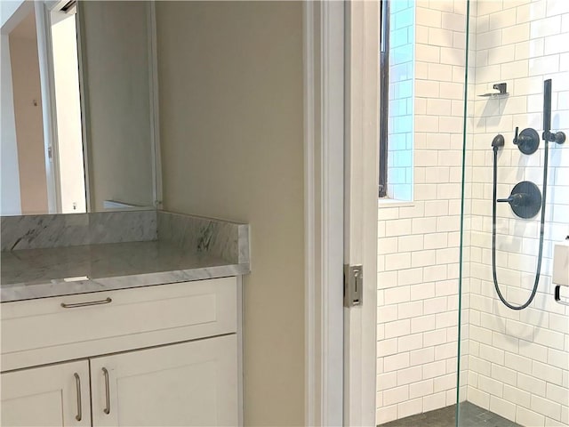 bathroom with vanity and tiled shower