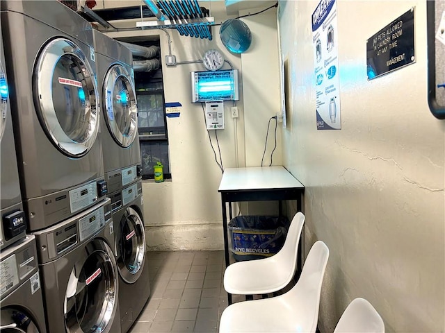 clothes washing area featuring stacked washer / dryer and tile patterned flooring