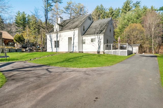 view of property exterior with a yard and an outdoor structure